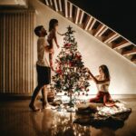 A family decorates a Christmas tree, bringing warmth and joy to the holiday season.